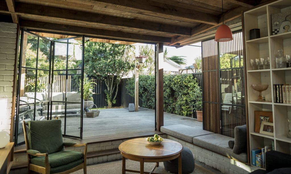 Living area opening out to a back garden via bifold steel doors