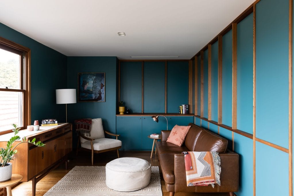 Mid century modern inspired living room with blue painted interior and timber accents