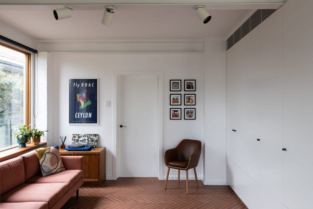 Renovated living room with mid century modern furniture and chevron tiled flooring