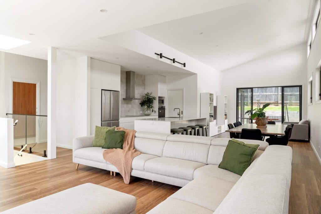 Wide view of an open plan living room, dining room and kitchen by YourBuild Construct