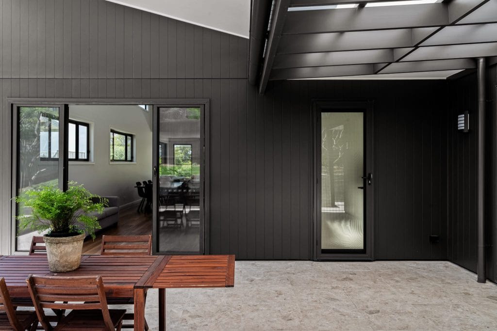 Tiled terrace with black painted exterior timber walls