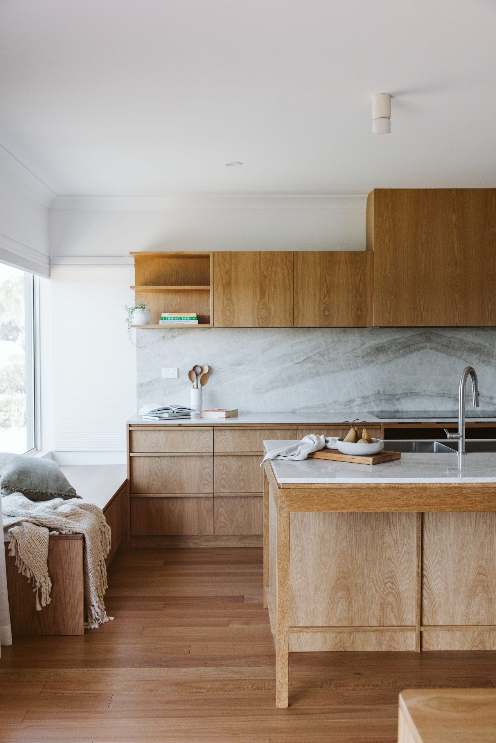 Timber kitchen and window seat detail with cushion and blanket