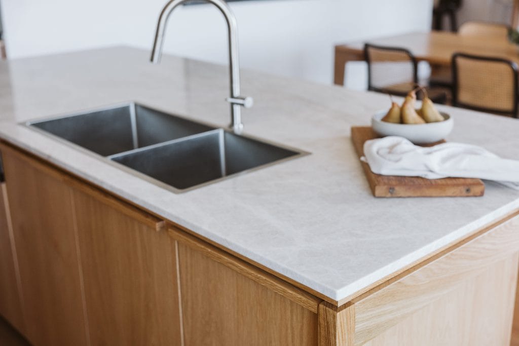 Details of kitchen island with grey benchtop and timber cabinetry