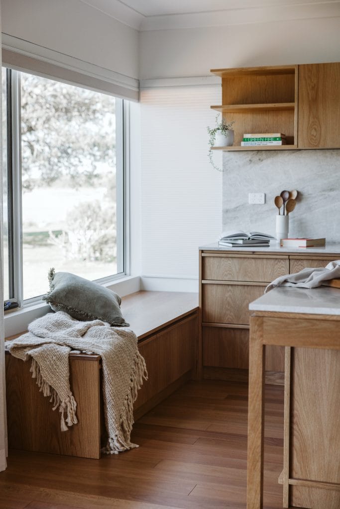 Timber kitchen and window seat detail with cushion and blanket
