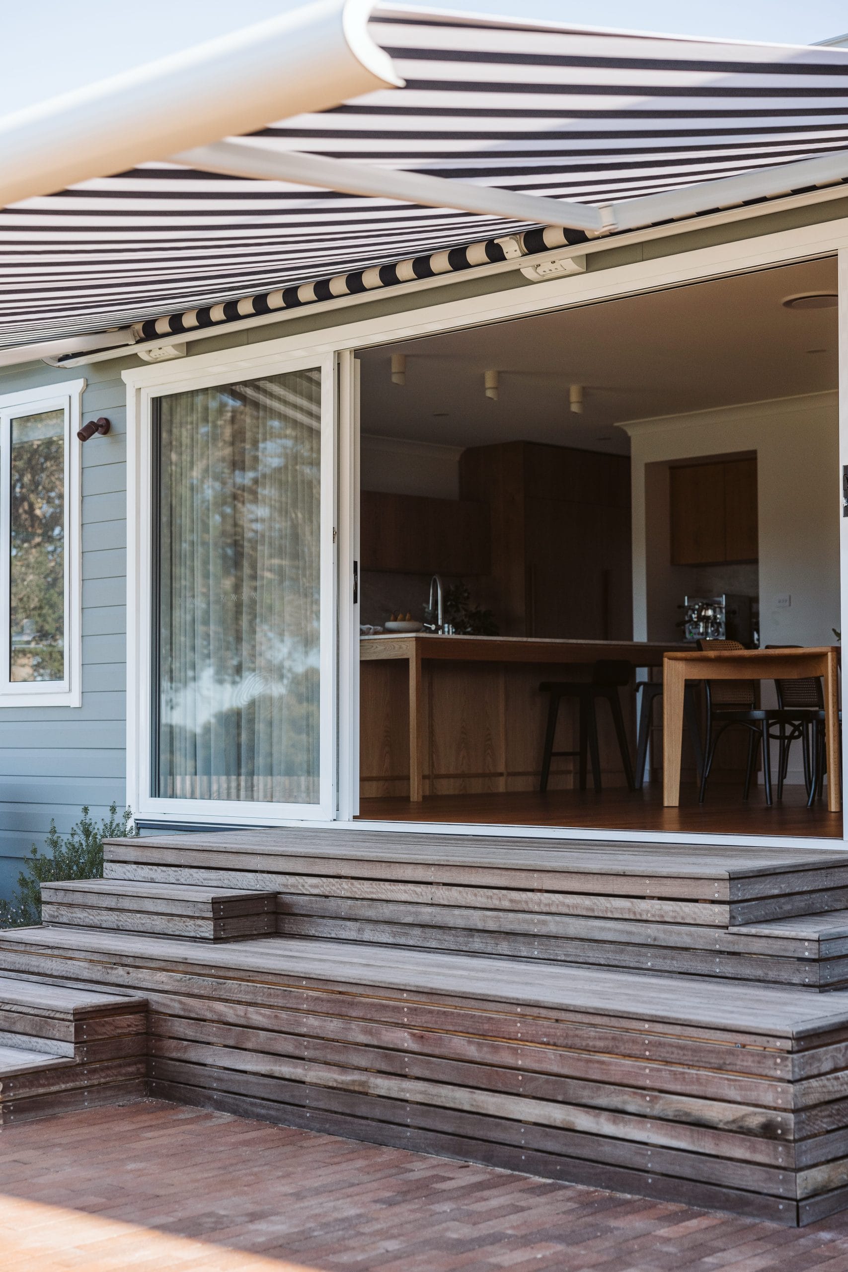 Exterior timber steps and striped black and white awning