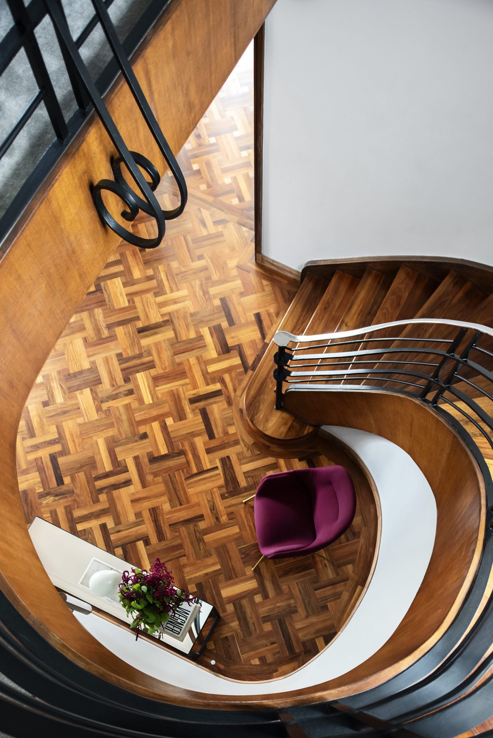 View from the top of a spiral staircase looking down to the parquetry floor below