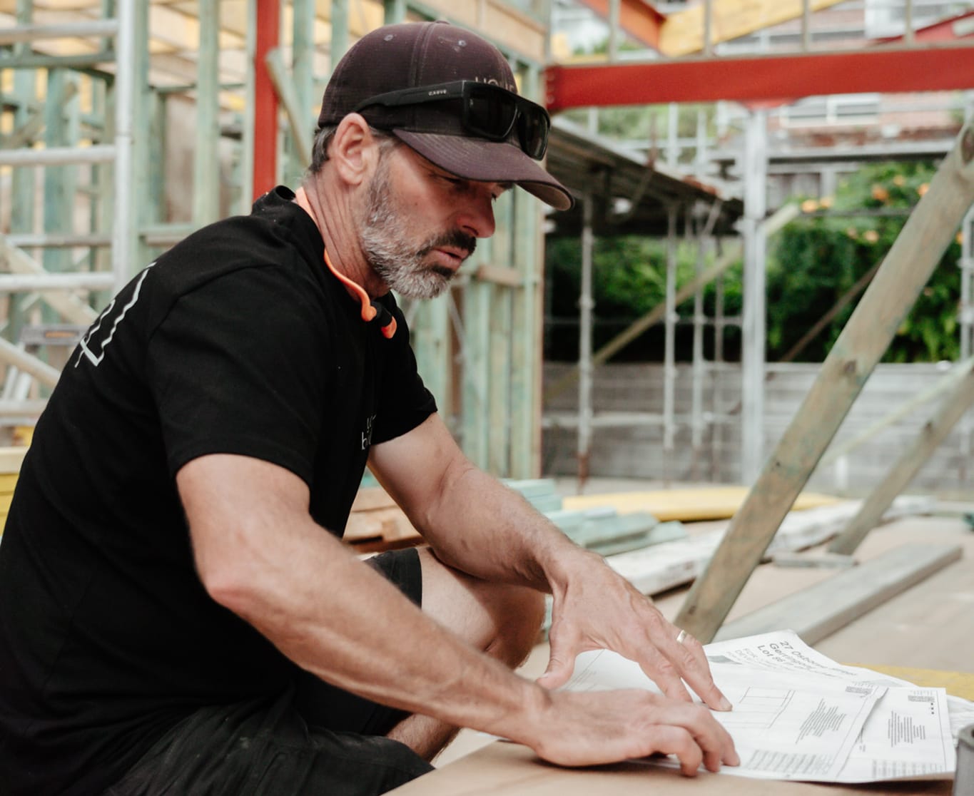 Tom from YourBuild Construct checking plans at a project building site in Gerringong