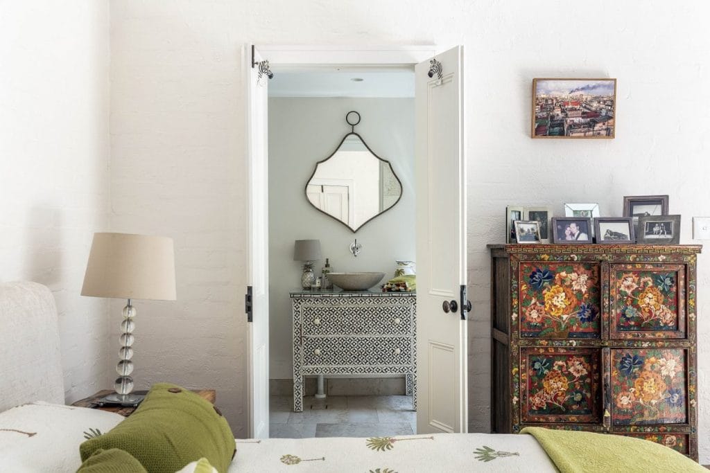 View from a bedroom through to an ensuite bathroom with vintage and eclectic decor