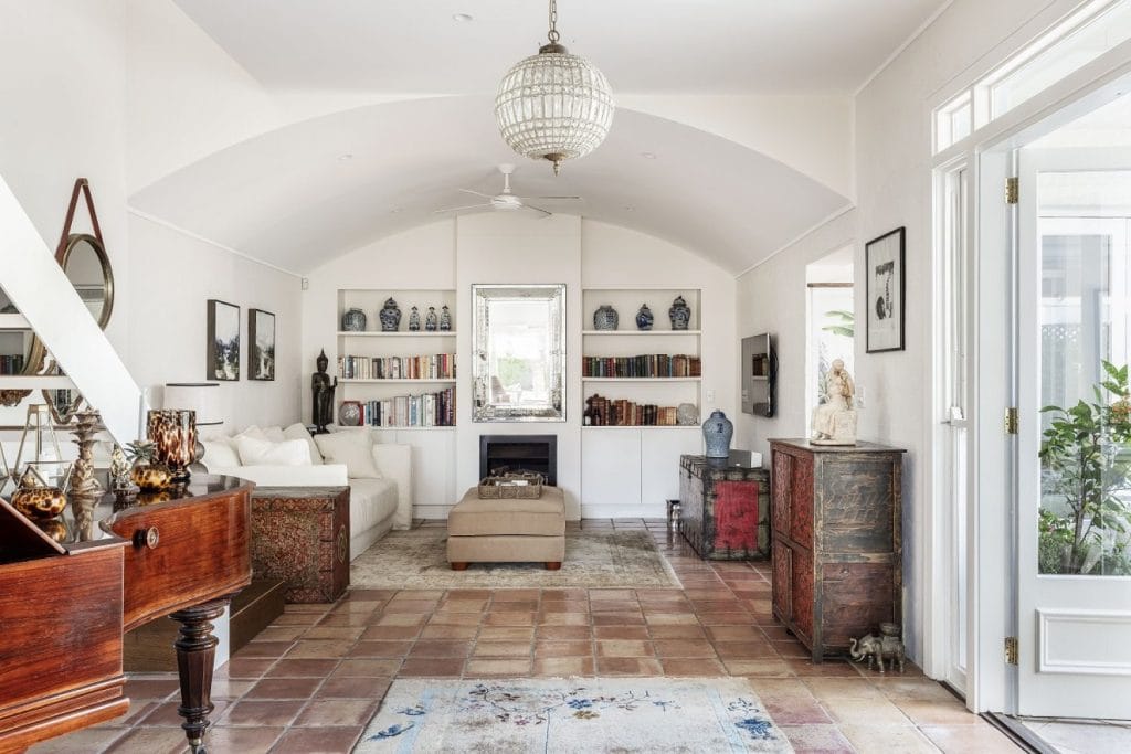 A tiled tv room with curved ceiling and eclectic furniture pieces