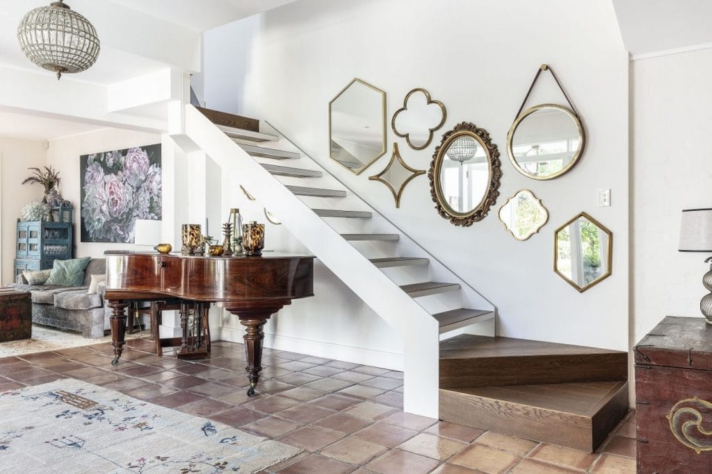 Open staircase in a Paddington terrace with an eclectic collection of vintage mirrors